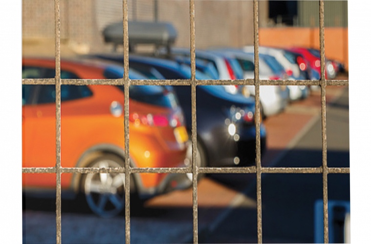 Cars viewed through a fence